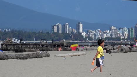 Stanley-Park-Und-Vancouver-Skyline-Und-Berge-Von-Einem-Strand-Aus-Gesehen