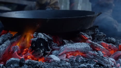 Große-Gusseiserne-Bratpfanne-Auf-Heißen-Orangefarbenen-Lagerfeuerglut-Im-Lager-Platziert