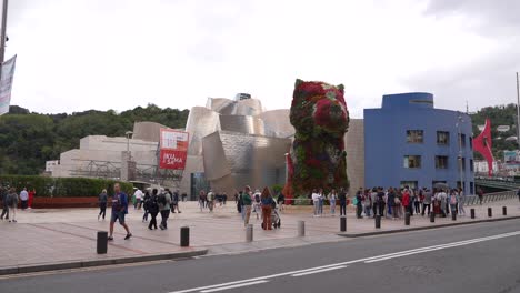 Bilbao,-Spain,-People-in-Front-of-Guggenheim-Museum-and-Puppy-Sculpture