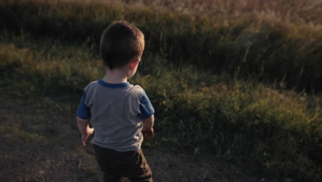 Un-Niño-Joven-Y-Feliz-Jugando-Afuera-Y-Tirando-Tierra-Al-Atardecer-En-Cámara-Lenta-Cinematográfica