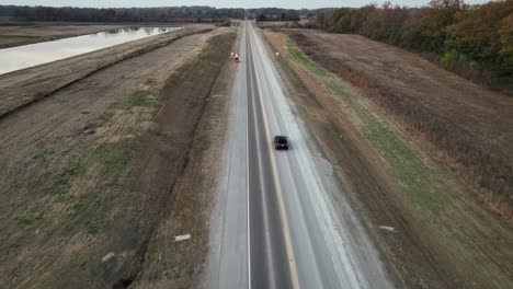 Aerial-following-behind-vehicle-traveling-alongside-Ford's-Megacampus,-BlueOval-City-at-Sunset-in-Stanton,-TN