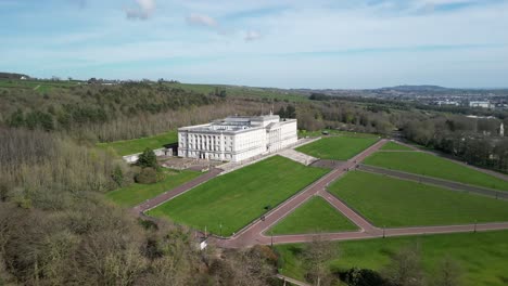 Cámara-Panorámica-Para-Revelar-Los-Edificios-Del-Parlamento-De-Stormont,-Belfast-Desde-Arriba-En-Un-Día-Soleado