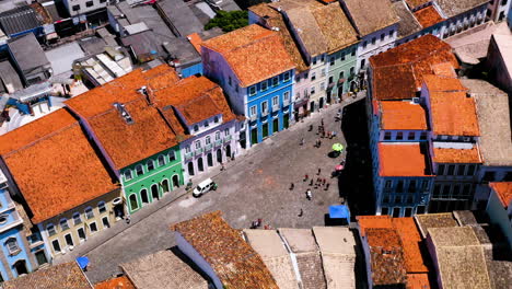 Aerial-view-of-the-colorful-houses-in-the-Pelourinho-neighbourhood-and-some-people-walking-around,-Salvador,-Bahia,-Brazil
