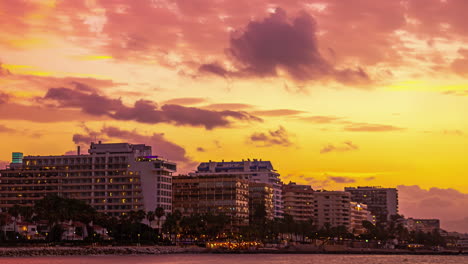 Timelapse-of-golden-sunset-where-clouds-disappear,-majestic-hues-over-Malaga,-Spain