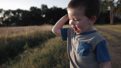 Un-Niño-Joven-Y-Feliz-Jugando-Afuera-Y-Tirando-Tierra-Al-Atardecer-En-Cámara-Lenta-Cinematográfica