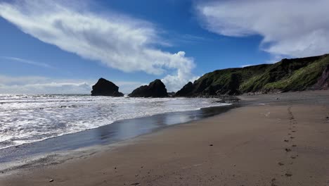 Fußspuren-Im-Sand,-Flut-Und-Schöne-Wolken,-Ballydwane-Beach,-Copper-Coast-In-Waterford,-Irland-An-Einem-Frühlingstag