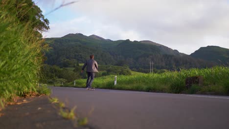 Skateboarding-in-the-middle-of-a-green-mountain-valley