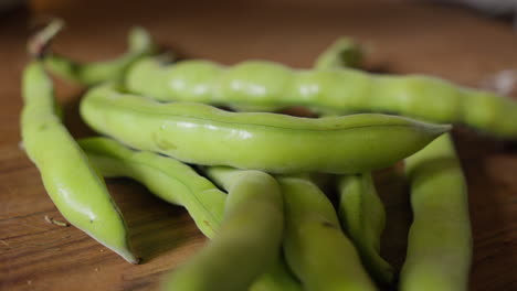 Fresh-green-broad-beans-on-wooden-surface