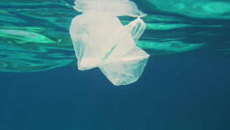 White-transluscent-plastic-bag-floats-in-clear-ocean-water-surface-at-tropical-setting