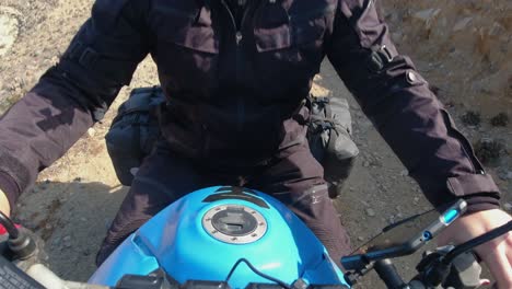 Body-of-moto-rider-seen-in-rugged-POV-gravel-road-motorcycle-selfie