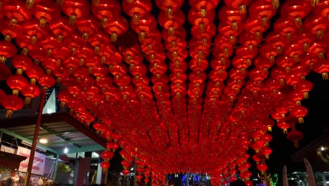 Imagen-En-Movimiento-Inclinada-Hacia-Arriba-De-Una-Lámpara-China-Roja-Tradicional-En-La-Ciudad-Durante-La-Noche,-China