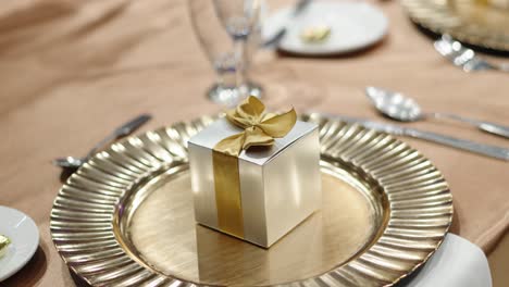 Eine-Kleine-Geschenkbox-Für-Gäste-Neben-Besteck-Bei-Einem-Hochzeitsessen
