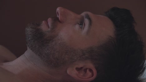Close-up-shot-of-a-attractive-man-with-facial-hair-lying-on-a-masseuse-table