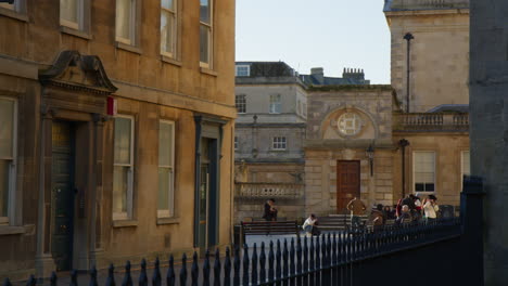 People-On-Street-With-Traditional-Architecture-In-Bath,-Somerset,-UK