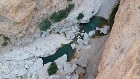 Aerial-drone-of-amazing-Wadi-Tiwi-oasis-with-turquoise-water-and-canyon-in-the-Sultanate-of-Oman
