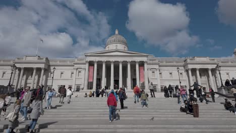 Daytime-footage-captures-pedestrians-walking-on-Trafalgar-Square-stairs-toward-London's-National-Portrait-Gallery,-a-concept-of-cultural-heritage
