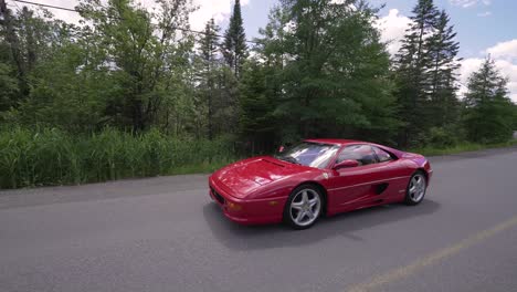 Red-Ferrari-355GTS-driving-on-a-country-road---Following-side-view