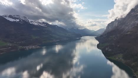 Aerial-footage-of-the-picturesque-Walensee-in-Switzerland,-with-snow-capped-mountain-tops-surrounding-the-lake