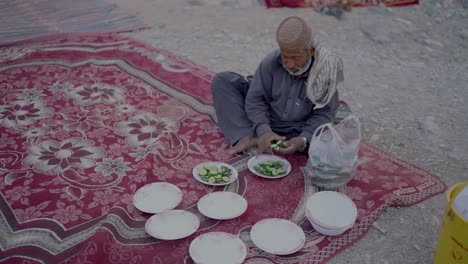 Profile-view-of-a-man-cutting-cucumber-into-slices-for-Ramadan-iftar-in-Balochistan,-Pakistan