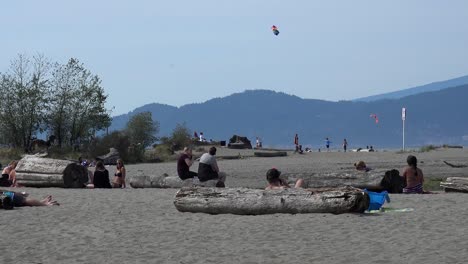 Eine-Gruppe-Von-Menschen-Beobachtet-Einen-Großen-Drachen-Beim-Fliegen-Am-Strand