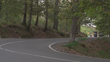 Los-Ciclistas-Recorren-Una-Carretera-Curva-En-El-Bosque.