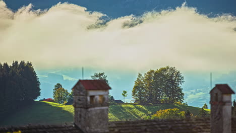 Time-Lapse-landscape-in-Austrian-alps-countryside-fields-traditional-houses-sky-in-motion,-clouds-moving,-traditional-architecture-in-grass-agricultural-fields