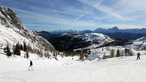 Skiing-people-at-Nassfeld-ski-resort-with-the-snowy-Austrian-Alps-in-the-background-during-winter