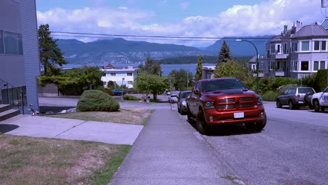 Walking-downhill-to-ocean,-Stanley-Park-in-background