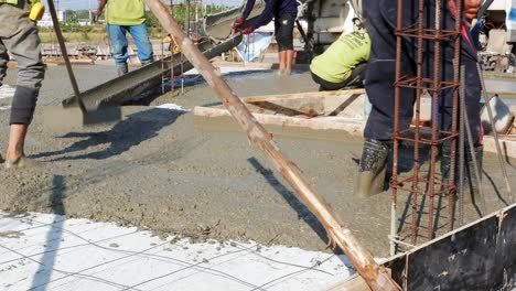 Migrant-construction-workers-mixing-cement-and-putting-them-in-place-as-they-are-buidling-a-new-establishment-in-a-district-in-Bangkok,-Thailand