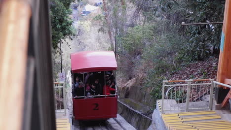 Red-Funicular-train-car-climbs-steep-slope-to-San-Cristobal,-Santiago