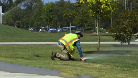 Ein-Mitarbeiter-Des-öffentlichen-Parks-überprüft-An-Einem-Heißen-Sommernachmittag-Die-Funktionalität-Eines-Grundwassersprühgeräts