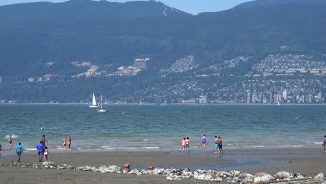 Kids-playing-in-waves-on-a-beach-in-Vancouver