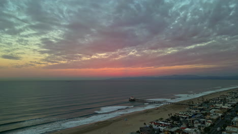 Aerial-panoramic-sunset-beach-coastline-of-manhattan-beach-california-American-skyline-with-golden-pink-tones,-front-coastline-buildings