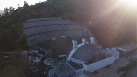 Descending-and-panning-aerial-shot-of-the-Hollywood-Bowl-with-lens-flare-at-sunset-in-Los-Angeles,-California