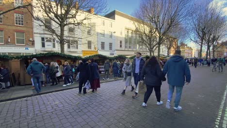 Eine-Belebte-Straße-Im-Stadtzentrum-Erwacht-Zum-Leben-Und-Weihnachtsstimmung,-Während-Fußgänger-Unter-Einem-Klaren-Blauen-Himmel-An-Geschmückten-Geschäften-Und-Festlichen-Weihnachtsdekorationen-Vorbeischlendern