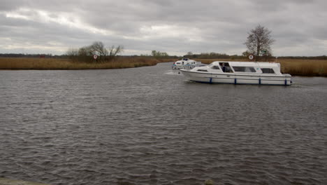 wide-shot-of-a-white-Norfolk-Broads-cruiser-boat-passing-the-entry-to-South-Walsham-Broad