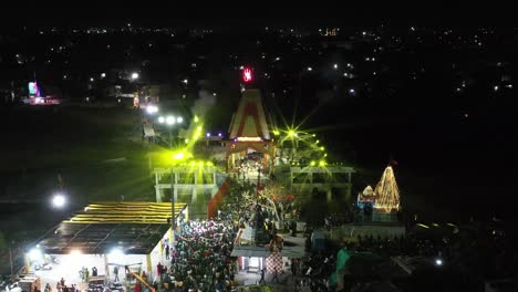 AERIAL-DRONE-VIEW-Drone-camera-moving-forward-where-many-people-are-watching-the-light-show-of-Mahadev's-Shivling