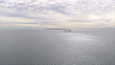 Cargo-Ship-leaving-Table-Bay,-with-Robben-Island-in-the-background