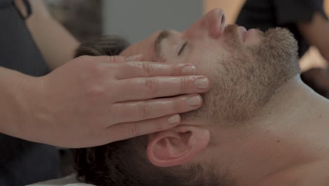 Close-ups-of-a-head-massage-of-a-man-with-a-young-beard