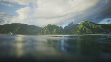 Tahitian-island-mountains-reflect-in-ocean-water,-view-from-surface