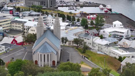 Aerial-View-of-Church-Above-Cityscape-and-Port-of-Akureyri,-Iceland