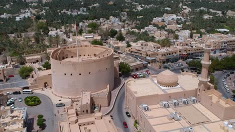 Aerial-of-Nizwa-with-historic-fort,-castle-and-walls-in-the-Sultanate-of-Oman