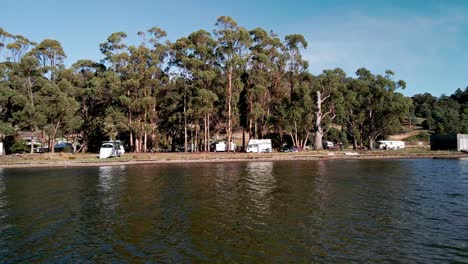 Camper-Vans-And-Motorhomes-Parked-On-The-Shore-In-Bruny-Island,-Tasmania,-Australia---Aerial-Sideways