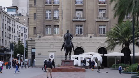 People-walk-past-statue-of-Pedro-de-Valdivia-on-horseback-in-Santiago