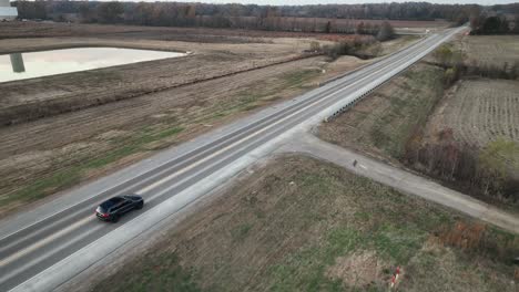 Aerial-following-vehicle-driving-in-front-of-Ford's-Megacampus,-BlueOval-City-at-Sunset-in-Stanton,-TN