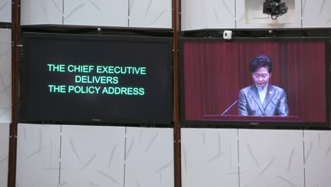 Carrie-Lam,-Ehemalige-Regierungschefin-Von-Hongkong,-Ist-Auf-Dem-Bildschirm-Des-Hauptsaals-Zu-Sehen,-Während-Sie-Im-Gebäude-Des-Legislativrats-Ihre-Jährliche-Politische-Ansprache-Hält.