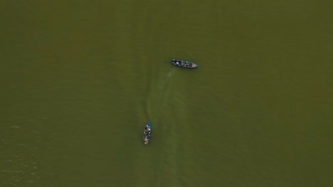 View-from-above,-stunning-aerial-view-of-some-boat-and-tourist-passing-trough-in-a-beautiful,-green-sea