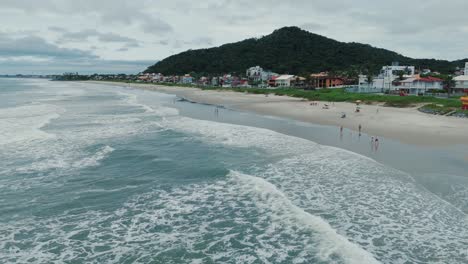 Aerial-of-Populated-Sandy-Beach-near-Ocean-and-City,-Summertime-Brazil