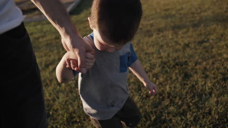 Happy-father-and-son-holding-hands-and-walking-in-cinematic-slow-motion
