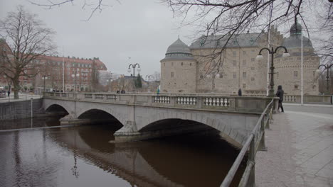 Grey-winter-day,-svartån,-storbron-and-the-castle,-Örebro-slott,-handheld